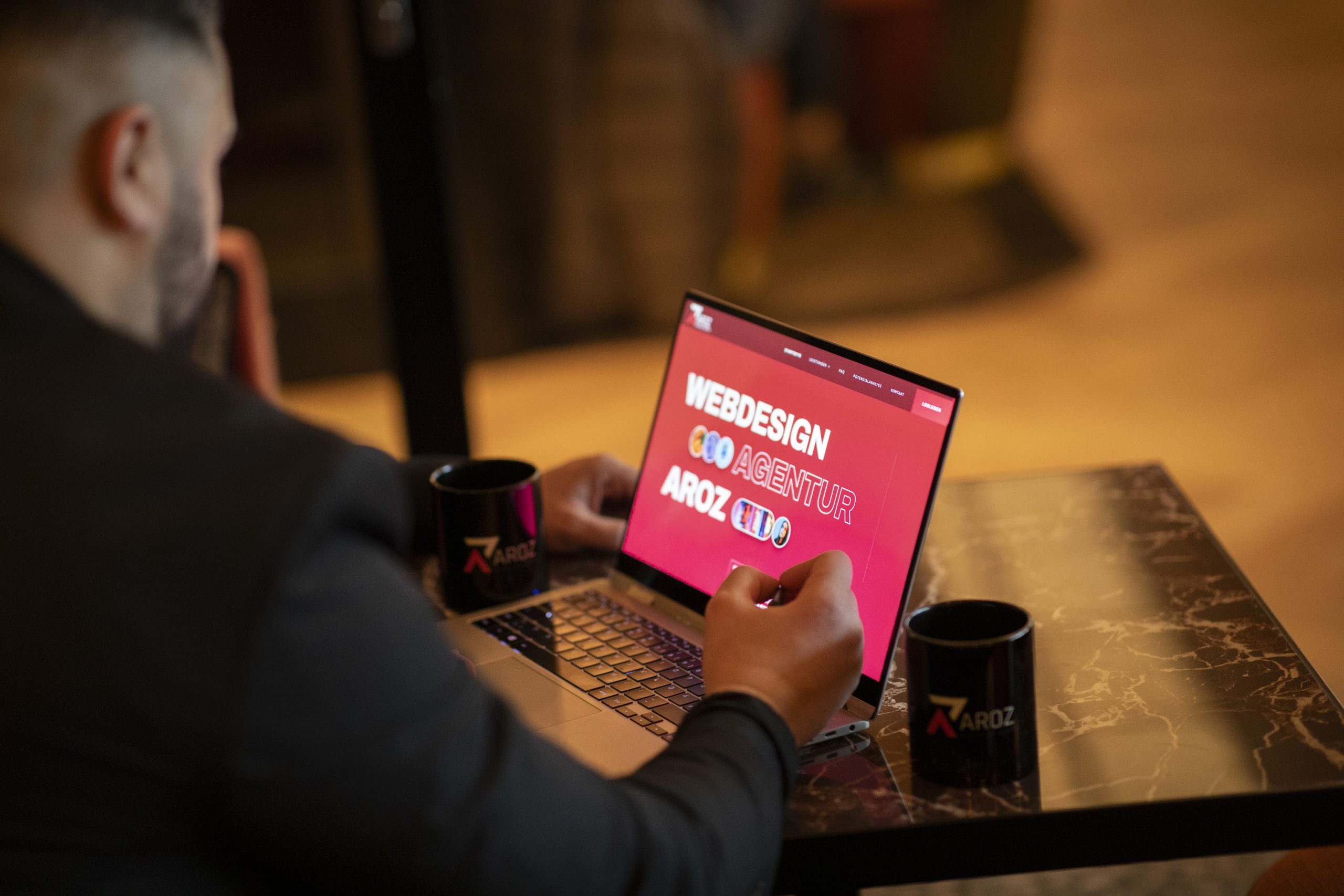 Startseite 16 Ein Bild zeigt einen Laptop mit dem Logo der Aroz Webdesign Agentur auf dem Bildschirm, umgeben von verschiedenen grafischen Elementen, die die verschiedenen Aspekte der Website-Gestaltung und digitalen Präsenz darstellen. Die Szene strahlt Professionalität und Kreativität aus und betont die Bedeutung einer durchdachten Webpräsenzgestaltung. Dieses Bild verkörpert das Engagement der Aroz Webdesign Agentur für die Erstellung ansprechender Online-Präsenzen und die Nutzung innovativer Online-Designkonzepte.